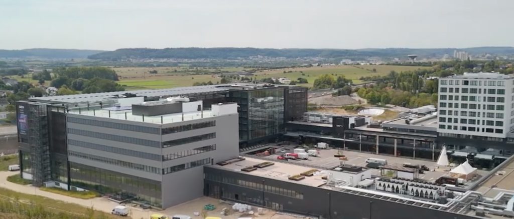 Moderne kantoorcomplex met groen landschap op achtergrond.