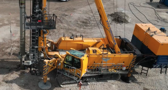 Geel bouwvoertuig op zandgrond operationeel.