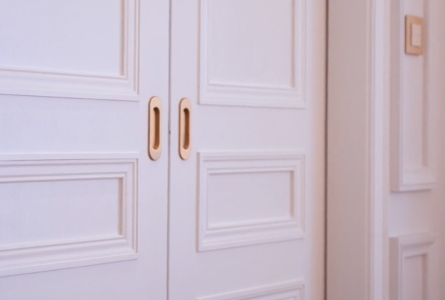 Witte dubbele deuren met gouden handgrepen