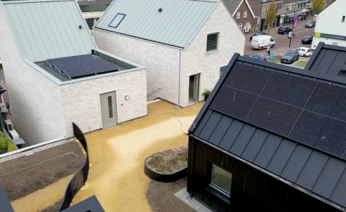 Moderne huizen met zonnepanelen in rustige wijk.