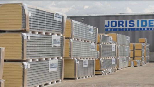 Stalen isolatiepanelen gestapeld buiten opslagfaciliteit.