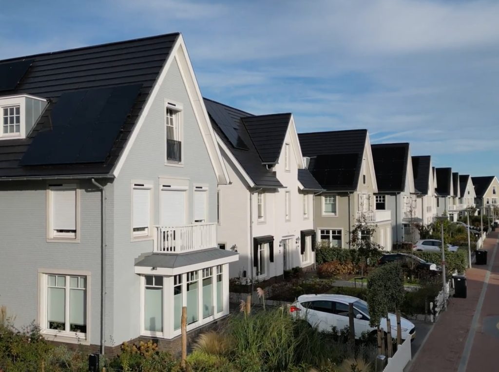 Rij moderne huizen met zonnepanelen en tuinen