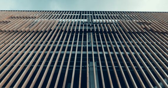 Gevel met horizontale houten latten tegen blauwe lucht