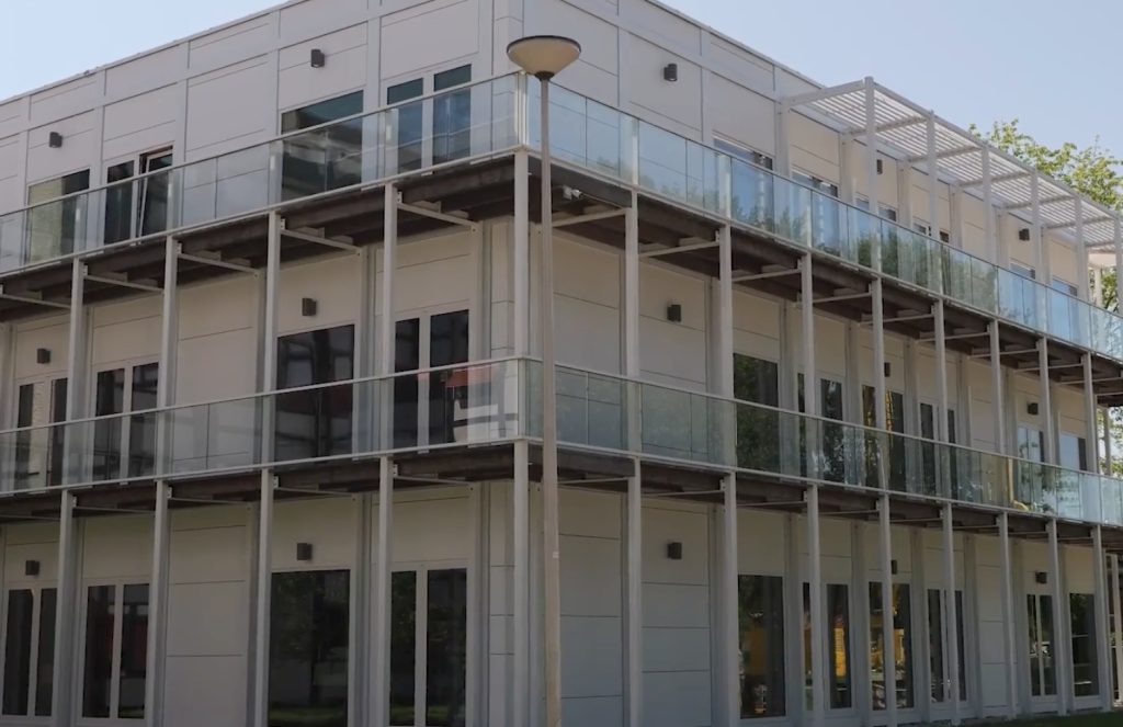 Modern gebouw met glazen balkons en stalen kolommen