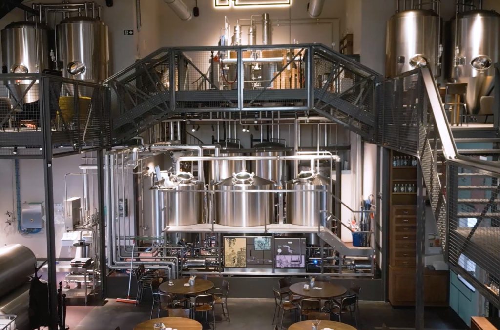 Moderne brouwerij met metaalconstructie en roestvrijstalen tanks.