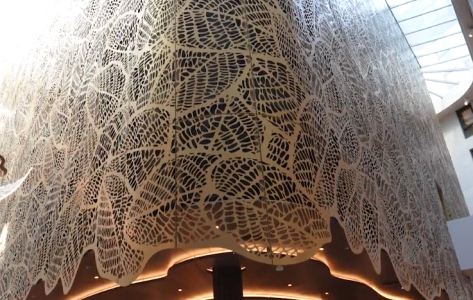 Groot wit kantachtig plafondontwerp in moderne ruimte.