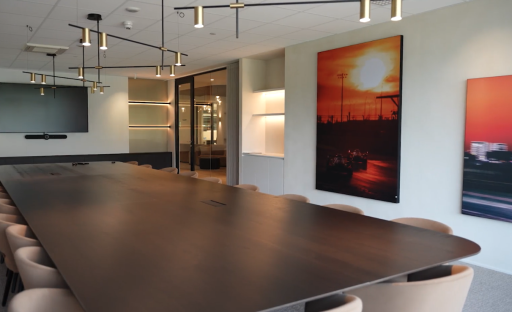 Vergaderruimte met lange tafel en muurkunstwerk