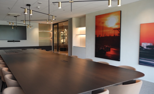 Vergaderruimte met lange tafel en muurkunstwerk