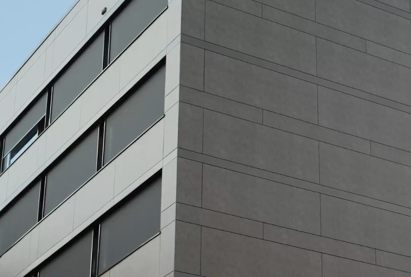 Grijze kantoorgebouw met ramen en gevelbekleding