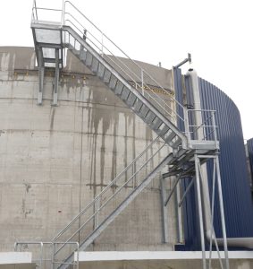 Stalen trap naast grote opslagtank