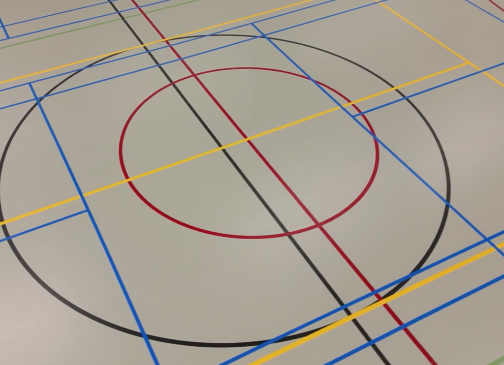 Vloer met gekleurde lijnen in sporthal.