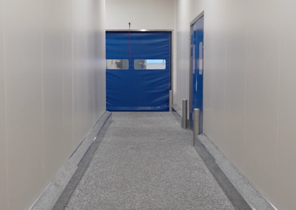 Lege gang met gesloten blauwe roldeur.