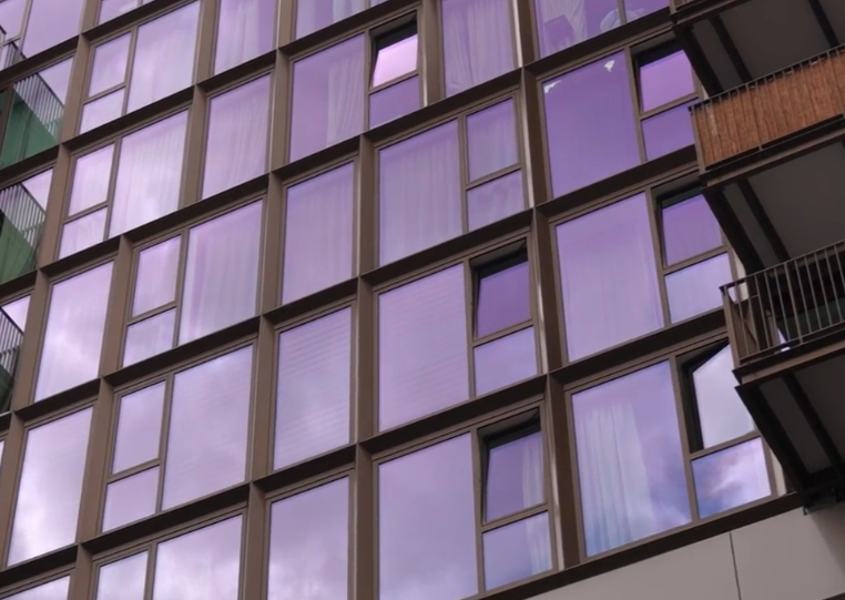 Flatgebouw met paarse ramen.